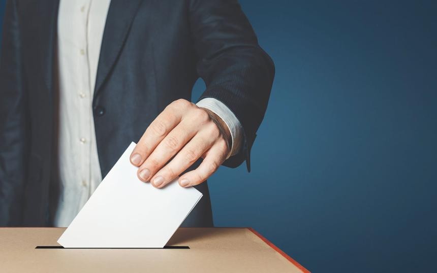 Symbolbild für Wahlen: Ein Wahlzettel wird in die Wahlurne gesteckt
