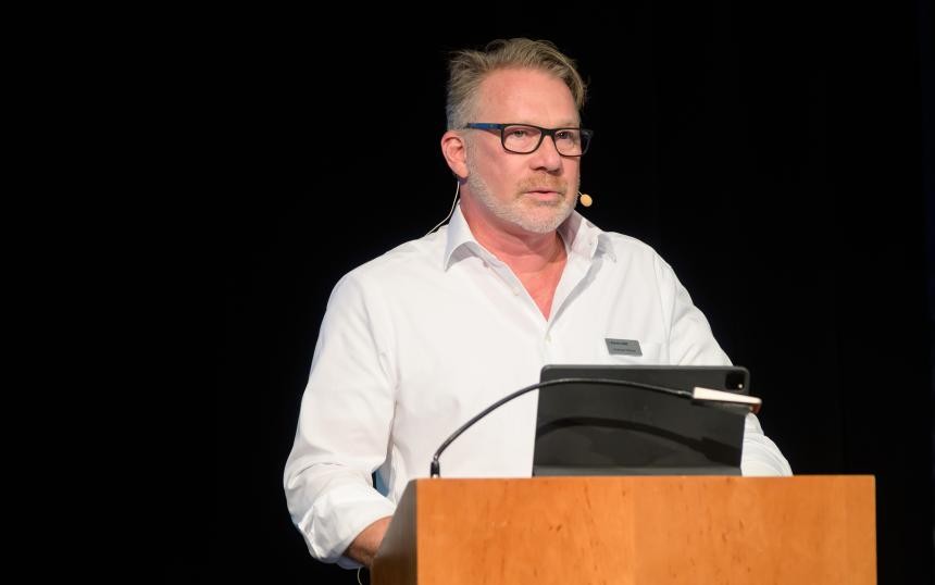 Andreas Pelzner (Vorstandsmitglied Komm.ONE) bei seiner Keynote Andreas Pelzner am Rednerpult