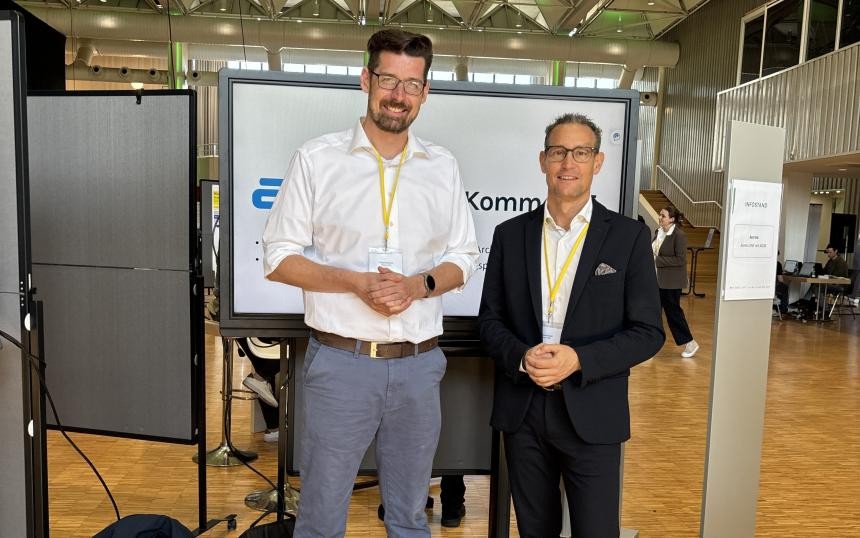 Zwischen den Gesprächen kurz ein Lächeln für die Kamera: Daniel Stöhlker, Innovationsmanager der Komm.ONE im Bereich Geschäftsfeldentwicklung, und William Schmitt, Vorstandsvorsitzender der Komm.ONE (von links nach rechts) Zwischen den Gesprächen kurz ein Lächeln für die Kamera: Daniel Stöhlker, Innovationsmanager der Komm.ONE im Bereich Geschäftsfeldentwicklung, und William Schmitt, Vorstandsvorsitzender der Komm.ONE (von links nach rechts)