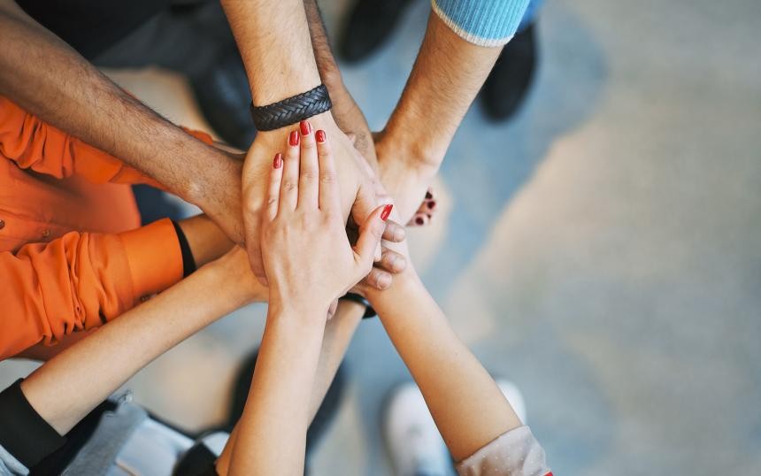 Hände mehrerer Personen übereinander